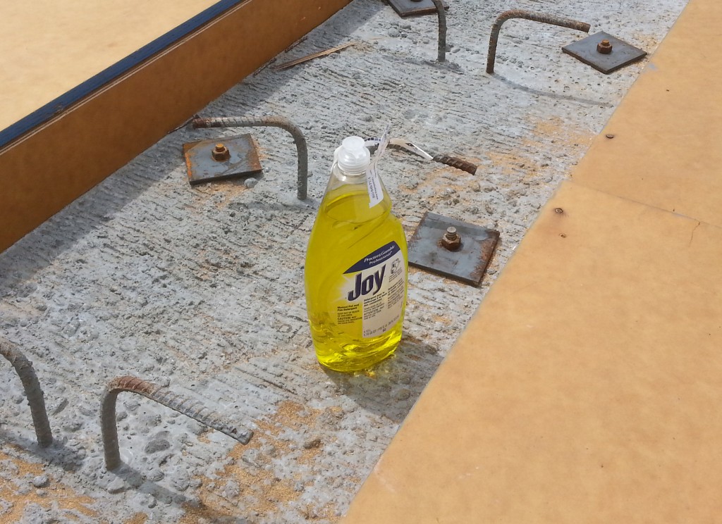 No, it’s not to keep the bridge clean during construction.  This bottle of dishwashing liquid helps slightly rusty nuts turn on to slightly rusty threads.