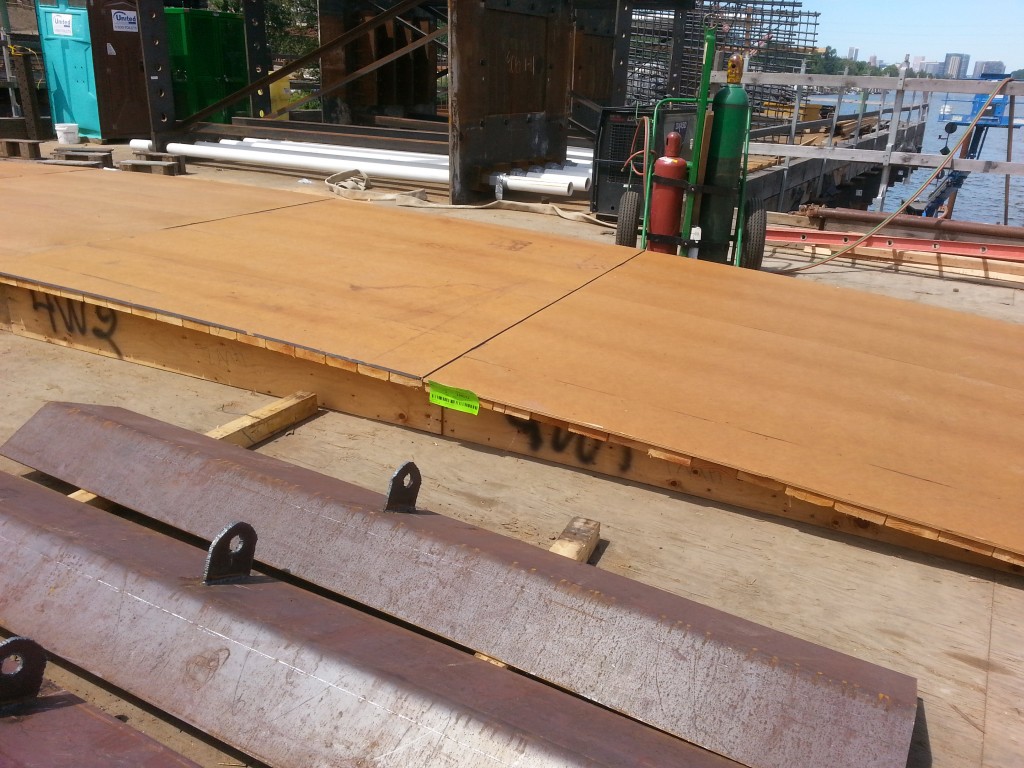 The big wooden piece with the green tag is a template for the sweep of the big steel support arches that will hold up the bridge.